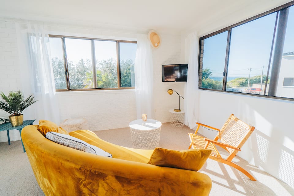 A bright and sunny living room with yellow furnishings